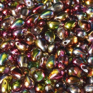 May include: A large pile of iridescent teardrop-shaped glass beads in shades of green, purple, and gold.