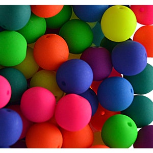May include: A pile of colourful, round, rubber beads in various bright colours, including green, blue, pink, orange, and purple.