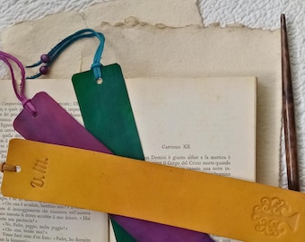 May include: Four leather bookmarks with a tree design. The bookmarks are in shades of green, purple, and yellow.
