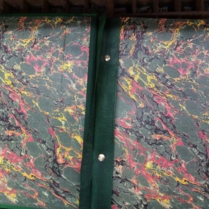 May include: Two green marbled book covers with a dark green spine and metal fasteners. The marbling is in shades of green, red, and yellow.