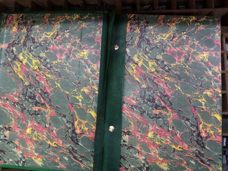 May include: Two green marbled book covers with a dark green spine and metal fasteners. The marbling is in shades of green, red, and yellow.