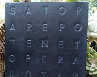 May include: A black leather square with the Latin palindrome "SATOR AREPO TENET OPERA ROTAS" embossed in white.