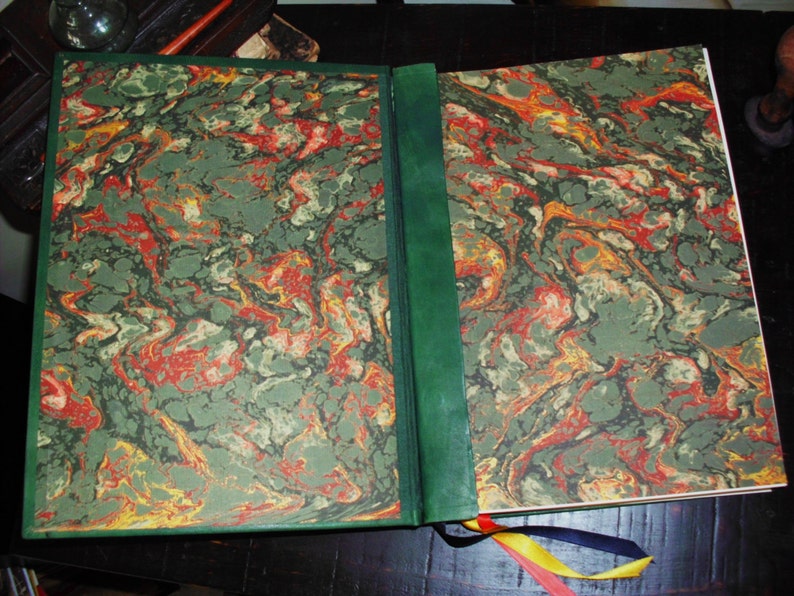 May include: A green, red, and yellow marbled book cover with a green leather spine.