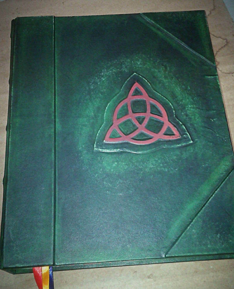 May include: A green leather-bound journal with a red, three-pointed star embossed on the front cover.