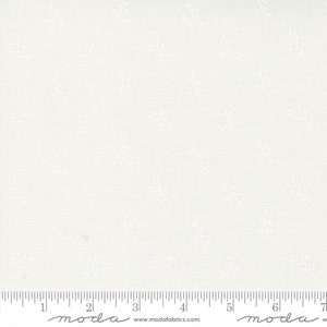May include: White fabric with a subtle, repeating pattern of small sprigs. The fabric is shown with a ruler, indicating it is sold by the metre.