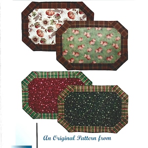 May include: Four different fabric placemats with a variety of patterns, including pumpkins, stars and plaid. The placemats are 21 inches by 15 inches. "Quick and Easy Placemats!" and "An Original Pattern from EB Designs by Eileen" are printed on the page.