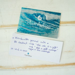 May include: A white card with handwritten instructions for adding a personal note to an order at checkout. The text reads: "*Handwritten personal note* At checkout: Tick "This order is a gift" and Add a gift message or send a card Type in the message"  The card also includes the name "Matt Adkins" and the words "Glass Relief".