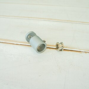 May include: A silver metal pipe fitting with a threaded end and a silver metal ring.