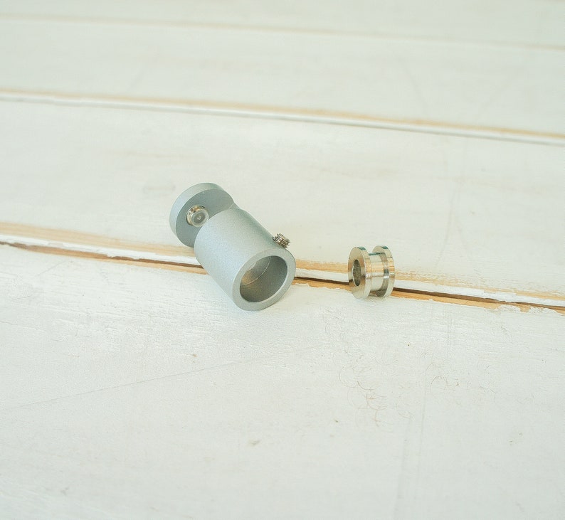 May include: A silver metal pipe fitting with a threaded end and a silver metal ring.