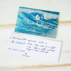 May include: A white card with blue text that reads "Matt Adkins Glass Relief". The card also has handwritten instructions for adding a personal note to an order at checkout.