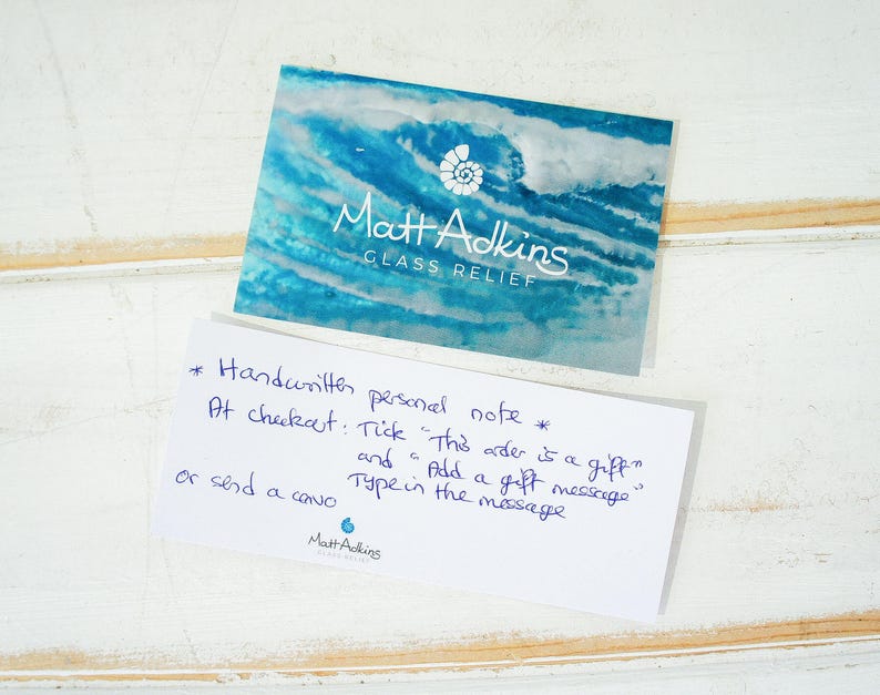 May include: A white card with blue text that reads "Matt Adkins Glass Relief". The card also has handwritten instructions for adding a personal note to an order at checkout.