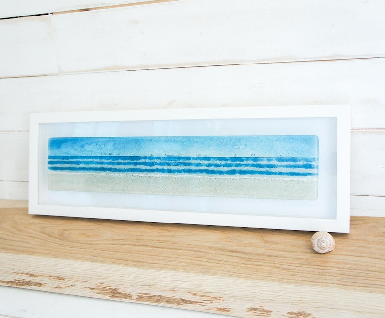 panoramic 3D fused glass blue beach scene wall art in a white wooden frame with cord across the back, ready to hang 60x20cm with cable across the back, handmade by glass artis Matt Adkins in Dorset, UK