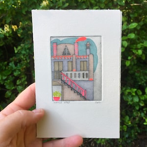 Könnte beinhalten: Aquarellillustration eines Gebäudes mit roter Treppe und Akzenten. Das Gebäude ist grau mit roten und orangen Verzierungen, einem türkisfarbenen Himmel und einem roten Schornstein. Der Name des Künstlers und das Jahr 2021 sind sichtbar.