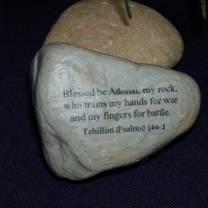 May include: A gray stone with the text "Blessed be Adonai, my rock, who trains my hands for war and my fingers for battle. Tehillim (Psalms) 144:1" printed on it.