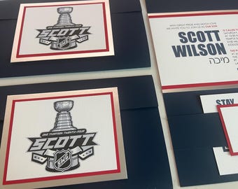 May include: A navy blue invitation with silver and red trim. The invitation is for a Bar Mitzvah celebration for Scott Wilson. The invitation features a hockey theme with a silver hockey trophy and the text "One Thirteen Twenty-Four Scott".