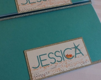 May include: Teal card with a white and gold glitter background. The name "Jessica" is written in a teal font with a gold star.