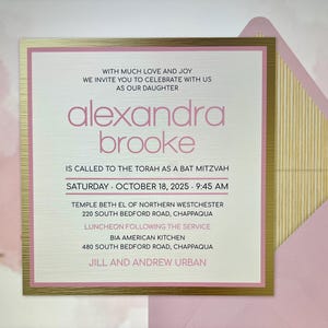 Peut inclure: Un faire-part de Bat Mitzvah carré avec une bordure métallique dorée et des accents roses. Le texte indique : WITH MUCH LOVE AND JOY WE INVITE YOU TO CELEBRATE WITH US AS OUR DAUGHTER alexandra brooke IS CALLED TO THE TORAH AS A BAT MITZVAH SATURDAY - OCTOBER 18, 2025 - 9:45 AM TEMPLE BETH EL OF NORTHERN WESTCHESTER 220 SOUTH BEDFORD ROAD, CHAPPAQUA LUNCHEON FOLLOWING THE SERVICE BIA AMERICAN KITCHEN 480 SOUTH BEDFORD ROAD, CHAPPAQUA JILL AND ANDREW URBAN. Il est accompagné d'une enveloppe rose avec une doublure dorée à rayures.