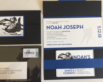 May include: Black and white invitation with blue accents for a Bar Mitzvah celebration. The invitation features a hockey player silhouette and the name "Noah Joseph". The date of the event is "5.12.18".