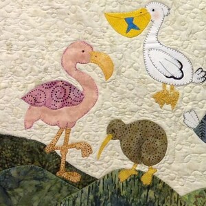 Puede incluir: Un edred&oacute;n textil con dise&ntilde;os de aves aplicados. Un flamenco rosa con pico amarillo y ala estampada se encuentra cerca de un kiwi marr&oacute;n con un pico largo amarillo. Tambi&eacute;n se presenta un pel&iacute;cano blanco con bolsa amarilla y pez azul.