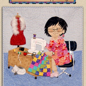 May include: A quilted wall hanging titled "Harebrained Happenings" featuring a cartoon woman sewing. The image includes a sewing machine, fabric scraps, a dress form, and a cat. The dimensions are 22" x 22".
