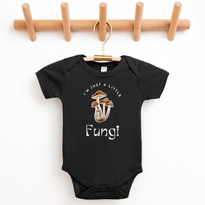 May include: Black baby onesie with a white graphic of mushrooms and the text "I'm just a little Fungi".