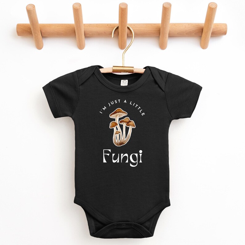 May include: Black baby onesie with a white graphic of mushrooms and the text "I'm just a little Fungi".