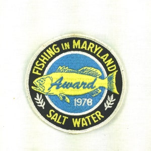 May include: A black and white embroidered patch with a yellow fish and the text "Fishing in Maryland Award 1978 Salt Water".