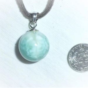 May include: A silver pendant necklace with a light blue and white round gemstone. The gemstone has a swirling pattern.
