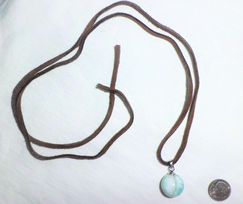 May include: A light blue and white gemstone pendant on a brown leather cord necklace.