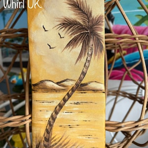 May include: A yellow silk tie featuring a painted image of a palm tree on a beach with a sunset sky. The text "Girl In A Whirl UK" is printed on the tie.
