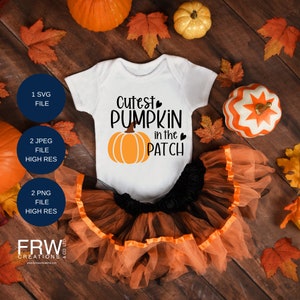 May include: A white babygrow with the text "Cutest Pumpkin in the Patch" and a small orange pumpkin graphic. The babygrow is paired with a black and orange tulle skirt. The image is surrounded by autumn leaves and pumpkins.