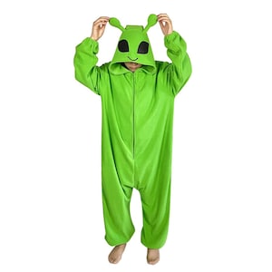 Könnte beinhalten: Ein leuchtend grüner Alien-Overall mit Kapuze, großen schwarzen Augen und Antennen. Der Kapuzen-Overall hat einen durchgehenden Reißverschluss und lange Ärmel. Der Anzug ist aus einem weichen, plüschigen Material gefertigt.