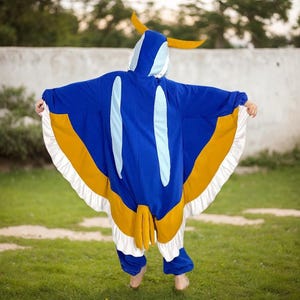May include: A blue and yellow butterfly-shaped onesie with a hood. The onesie has white accents and a ruffled edge.