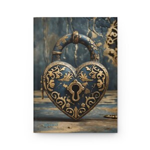 May include: A journal with a heart-shaped lock design. The lock is dark blue with gold filigree and a keyhole. The journal's cover has a distressed wood and stone background. The word "DEANEY" is printed on the bottom left corner.