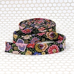 May include: A roll of fabric ribbon featuring a black background with a dense, colorful floral pattern. The print includes stylized flowers in shades of pink, yellow, blue, and green, arranged in a continuous, repeating botanical design.