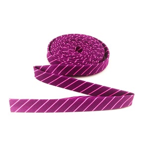 May include: A roll of purple and white striped fabric ribbon.