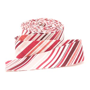 May include: A roll of fabric bias tape featuring a diagonal striped pattern in various shades of red, pink, and white. The tape is wound into a tight coil with one end extending outward, displaying the consistent multi-colored linear design.