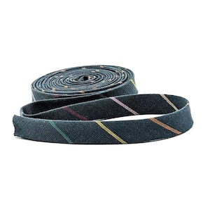 May include: A roll of dark gray fabric tape with diagonal stripes in yellow, pink, and green. The tape is unrolled, revealing a portion of the rolled-up section. The background is plain white.
