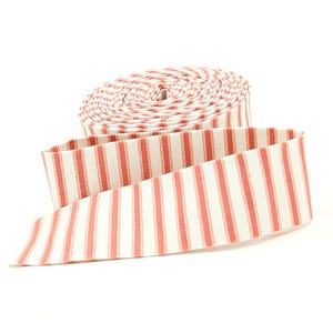 May include: A roll of red and white striped fabric ribbon, partially unrolled. The ribbon has a classic vertical stripe pattern. The fabric is a light color, and the stripes are a muted red. The ribbon is likely used for crafts or sewing projects.