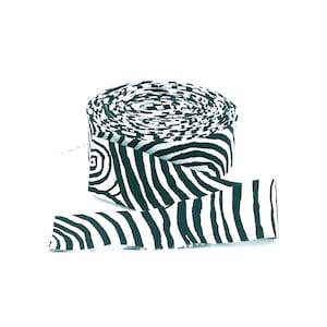 May include: A roll of fabric ribbon featuring a high-contrast black and white pattern of swirling, organic, and zebra-like stripes. The ribbon is tightly wound into a cylindrical shape with one end extending outward to display the continuous graphic print.
