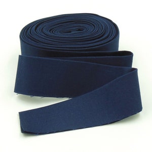 May include: A roll of dark blue fabric trim, folded and ready to be used for sewing projects.