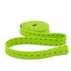 May include: A roll of lime green elastic with small blue polka dots. The elastic is folded in half and the ends are overlapping.