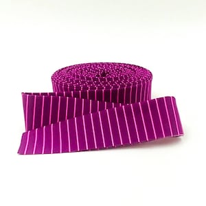 May include: A roll of dark magenta ribbon featuring a pattern of thin, vertical, lighter pink stripes. The ribbon is tightly wound into a circular spool, with one end extending outward to display the consistent striped design across its surface.