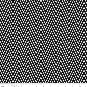 May include: Black and white chevron pattern fabric. The design features a repeating zigzag pattern with black and white lines. The fabric has a textured appearance and is suitable for various sewing projects. The image includes a ruler with inch measurements.