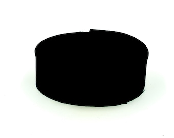 May include: A solid black, cylindrical container with a flat top and vertical sides. The object has a smooth, uniform appearance and a circular base, presented against a plain white background to highlight its simple, geometric form and structure.