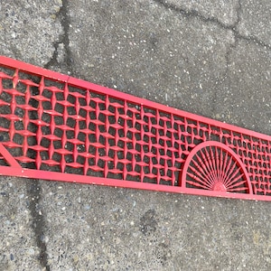 May include: A long, red wooden lattice panel with a geometric design. The panel features two fan-shaped designs at each end.