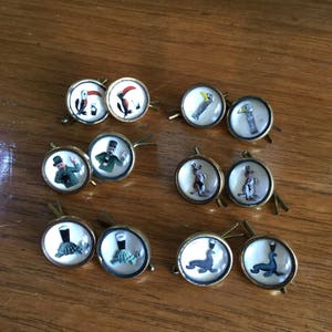 May include: Set of 10 vintage glass button cufflinks with various images, including a toucan, a kangaroo, a leprechaun, a turtle, and a seal. The cufflinks are gold-toned and have a clear glass dome.