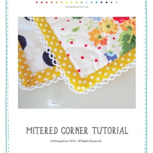May include: A tutorial on how to create a mitered corner using a double fold crochet edge bias tape. The image shows a close-up of a corner of a quilt with a yellow and white polka dot fabric and a white crochet trim.