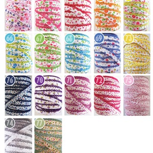 Peut inclure: Une collection de 15 bobines de ruban blanc avec diff&eacute;rents motifs floraux color&eacute;s et une bordure en dentelle. Les bobines sont num&eacute;rot&eacute;es de 61 &agrave; 77.