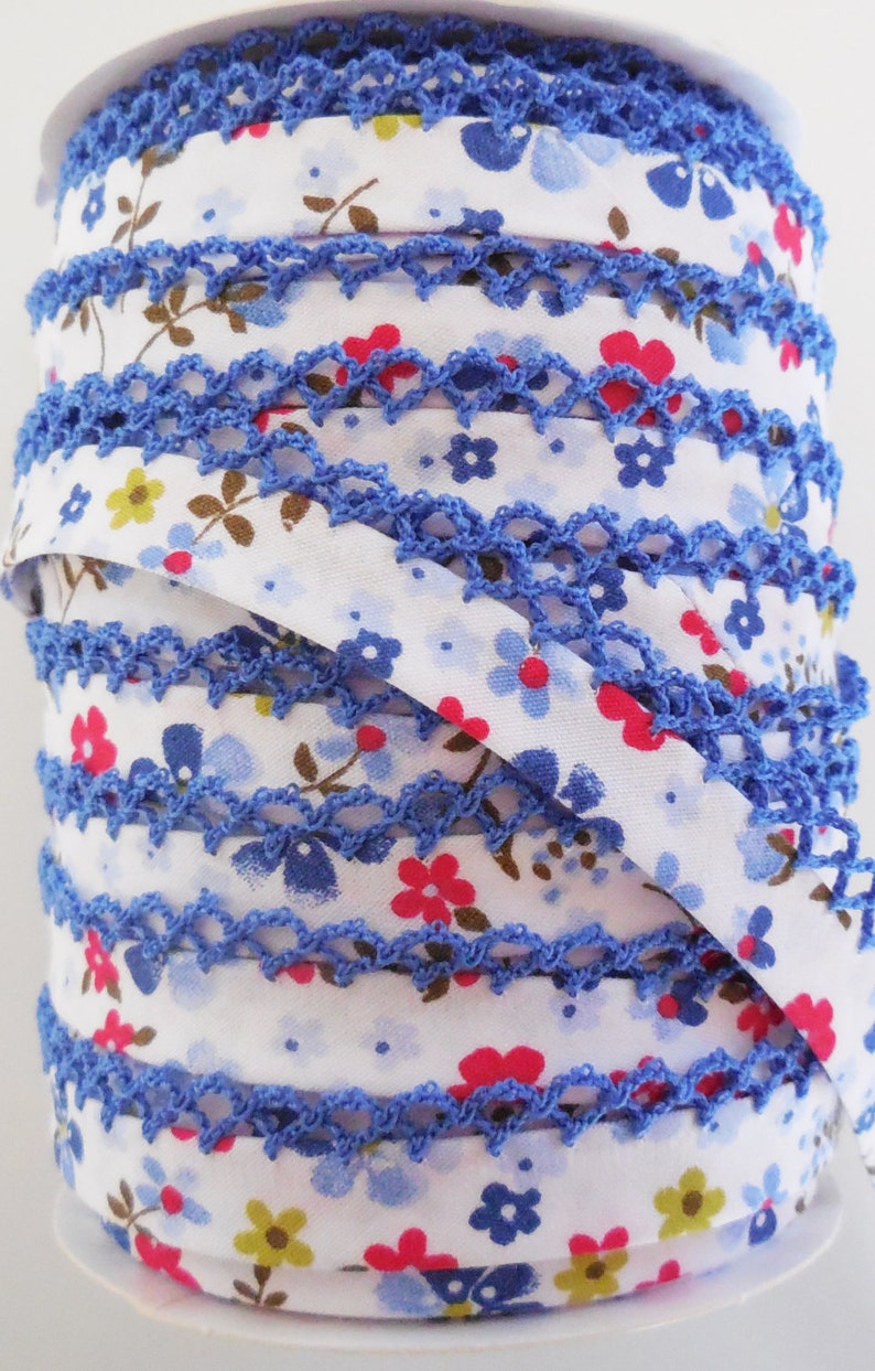 May include: A roll of blue and white floral trim with a crocheted edge. The trim is ideal for adding a touch of elegance to any project.
